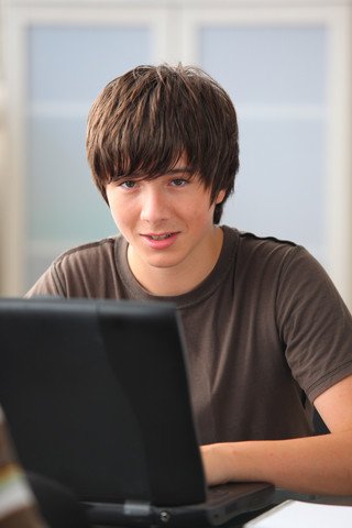 Gutt som skriver på datamaskin